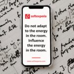 Phone displaying a Softexperia ad: red logo and the slogan 'Do not adapt to the energy in the room. Influence the energy in the room.' with the website at the bottom.